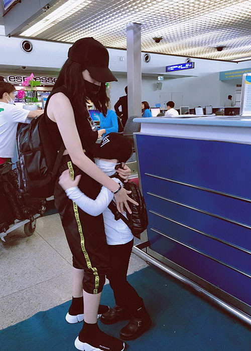 Hot girl Elly Trần vỗ về con trai ở sân bay.