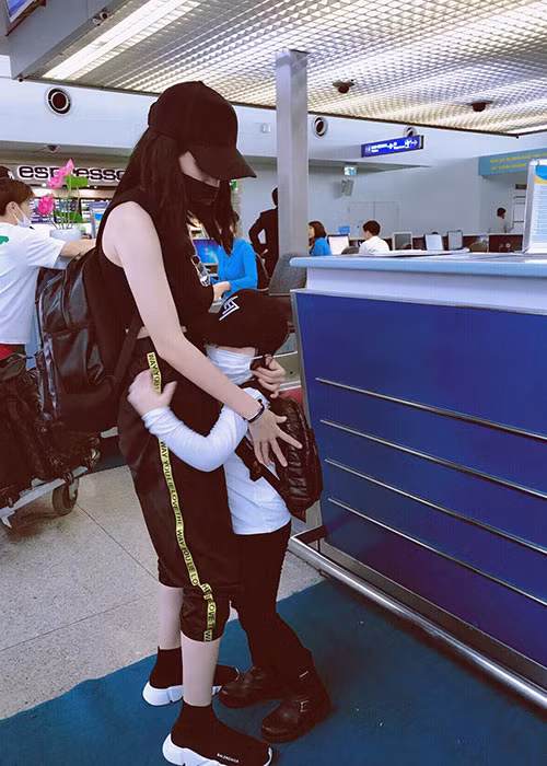 Hot girl Elly Trần vỗ về con trai ở sân bay.