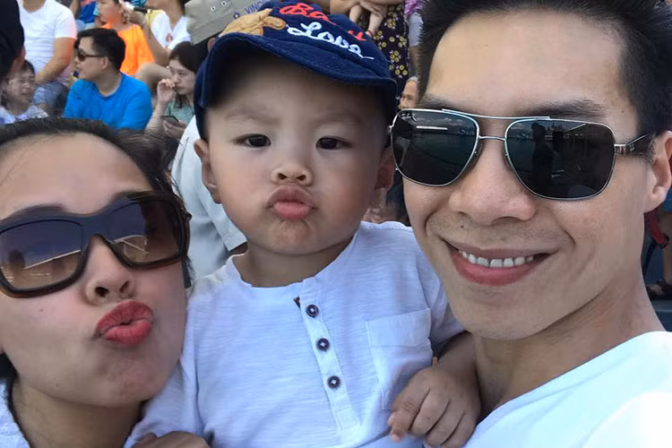Vợ chồng Quốc Nghiệp đưa con trai nhỏ đi xem cá heo biểu diễn.