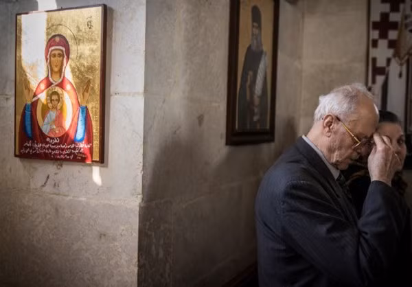 Cụ ông làm biểu tượng cầu nguyện trong một nhà nguyện ở Latakia.