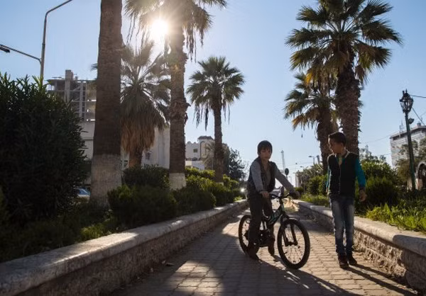 Bé trai đi dạo chơi trên phố cùng bạn.