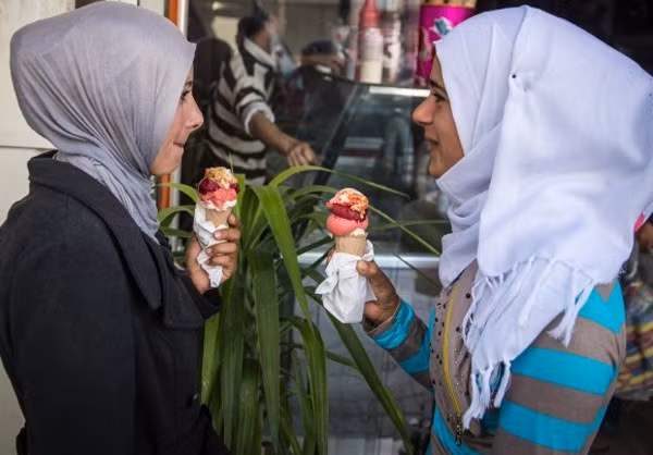 Hai cô gái ăn kem và trò chuyện cùng nhau ngoài phố.