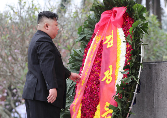 Chủ tịch Kim Jong-un cẩn thận sửa lại vòng hoa. Ảnh: NLĐ.