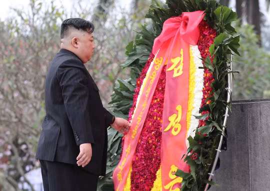 Chủ tịch Kim Jong-un cẩn thận sửa lại vòng hoa. Ảnh: NLĐ.