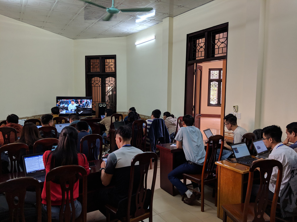 Các phóng viên dự đưa tin tòa qua màn hình tivi.