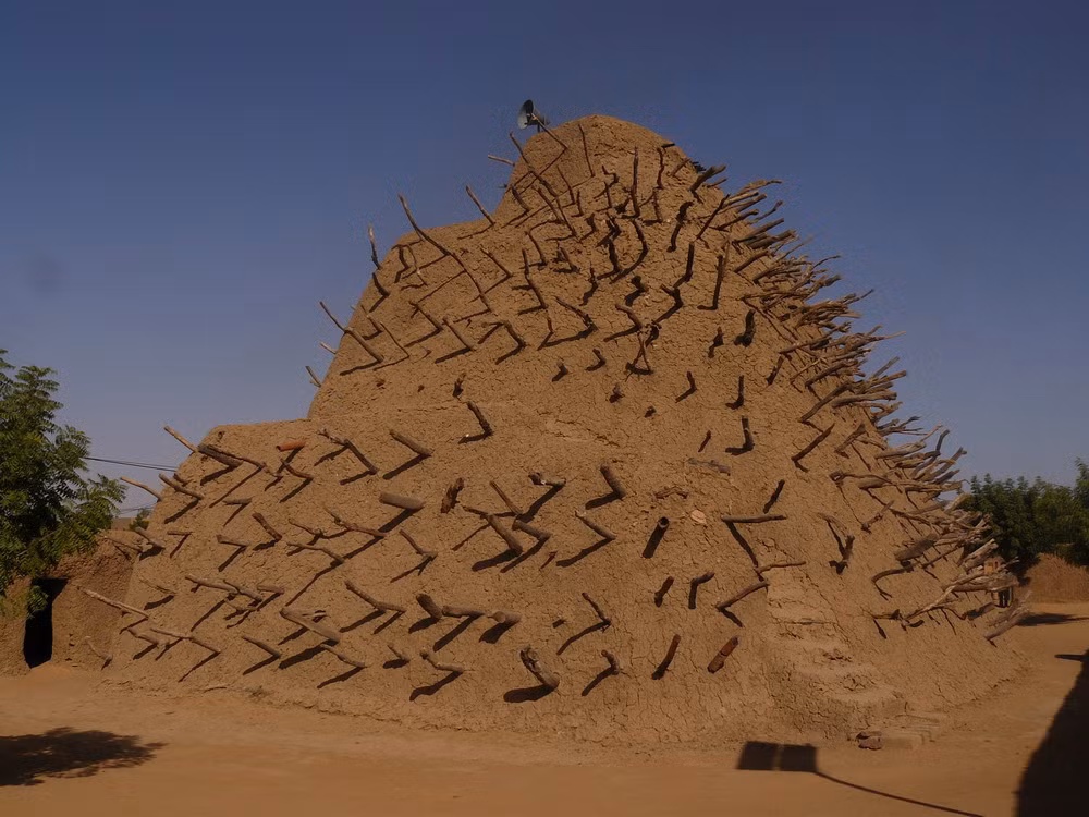 Công trình được xây dựng với nguyên liệu là bùn thạch cao, nguyên liệu truyền thống được các dân tộc Tây Phi sử dụng trong phong cách kiến trúc Sudano Sahel.