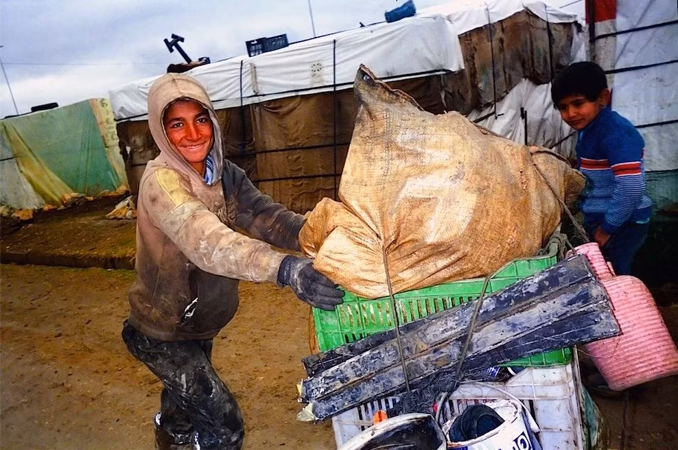 Hai cậu bé nhặt nhạnh đồ nhựa bỏ đi để mang bán kiếm tiền.