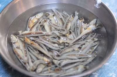 Trước tiên, cần ngâm cá cơm qua nước gạo khoảng 5 phút để loạt bớt vị mặn và sạn. Lạc rang chín giòn với dầu ăn. Ảnh: Trùm đặc sản.