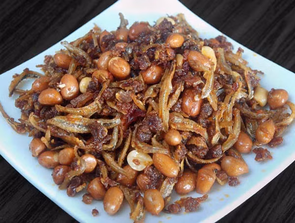  Cá cơm sốt cay lạc rang: Cá thấm đẫm gia vị kèm thêm vị bùi bùi, ngậy ngậy của lạc rang sẽ là món ngon khó cưỡng trong mâm cơm nhà bạn. Để chế biến món này, cần chuẩn bị nguyên liệu sau: Lạc, cá cơm khô, sốt me chua, dầu ăn, đường, tỏi, ớt, hành… Ảnh: Cá kho làng vũ đại.