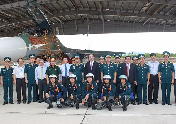 Hình ảnh máy bay tiêm kích Su-27 của KQND Việt Nam đổi màu ngụy trang mới được tờ báo của Quân chủng Phòng không – Không quân đăng tải. Ảnh: Chủ tịch nước Trần Đại Quang cùng đoàn cán bộ, sĩ quan, phi công Trung đoàn 925 chụp cùng chiếc Su-27UBK hai chỗ ngồi dùng màu ngụy trang cỏ mía.