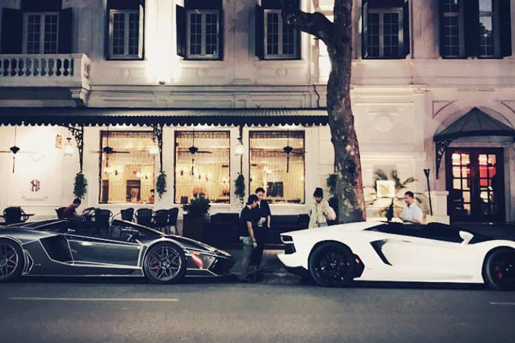 Đỗ cùng siêu xe Lamborghini Aventador mui trần màu trắng từng thuộc sở hữu của đại gia Cường Đô la trên đường phố Hà Nội còn có 1 "người bạn siêu bò mui trần" mang bộ áo đen crôm.