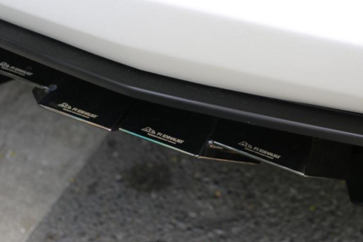 Phần ống xả độ FI cho siêu xe Lamborghini Aventador LP700-4 mui trần màu trắng được chủ nhân chọn lựa màu crôm đen. Trên bầu xả này có khắc dòng chữ "Lamborghini Aventador F1 No.73".