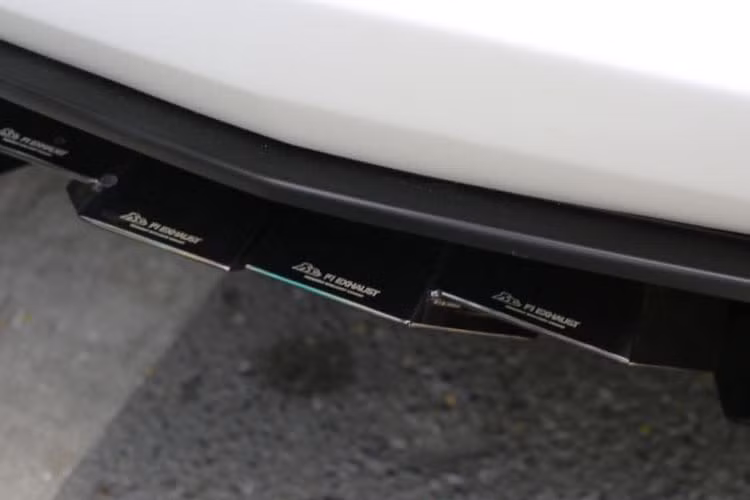 Phần ống xả độ FI cho siêu xe Lamborghini Aventador LP700-4 mui trần màu trắng được chủ nhân chọn lựa màu crôm đen. Trên bầu xả này có khắc dòng chữ "Lamborghini Aventador F1 No.73".