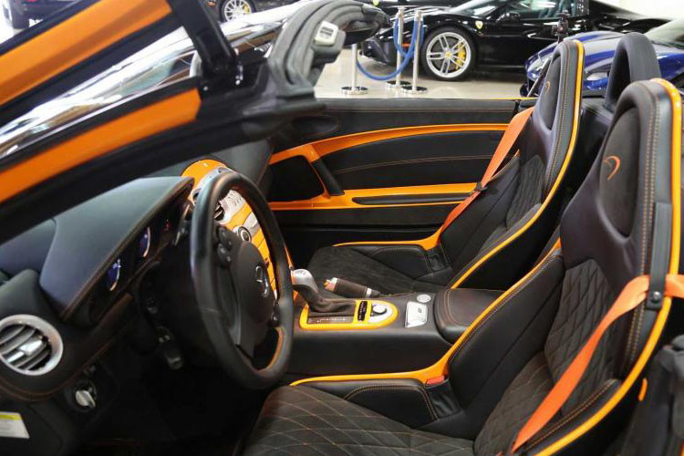 Bên trong khoang lái của siêu xe Mercedes-Benz SLR McLaren Edition Roadster bao gồm cặp ghế ngồi thể thao bọc da cao cấp màu đen kết hợp cùng sọc cam, thành cửa bọc da Alcantara màu đen kim cương, bệ cửa bằng sợi carbon