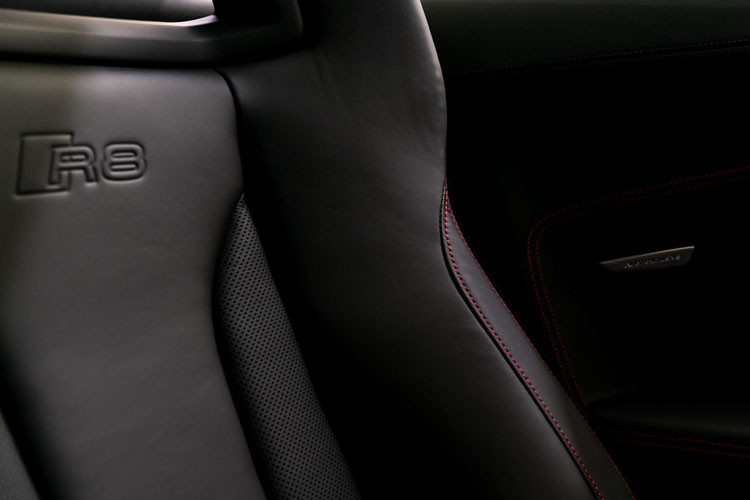 Các ghế ngồi được bọc da màu đen và khâu bằng chỉ đỏ tương phản.