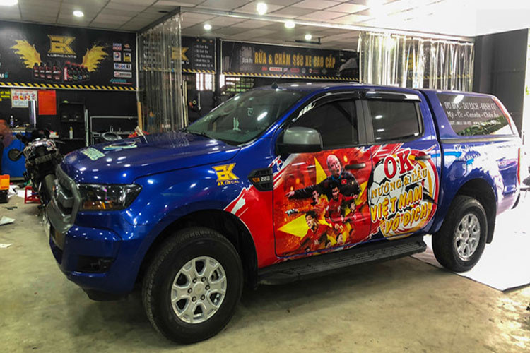 Ford Ranger dán hình thầy trò HLV Park Hang-seo, tone màu đỏ vàng của quốc kỳ nổi bật trên thân xe màu xanh.