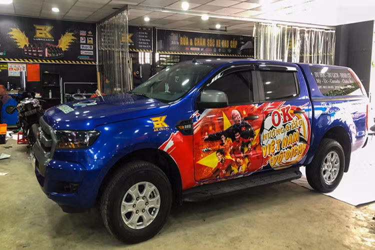 Ford Ranger dán hình thầy trò HLV Park Hang-seo, tone màu đỏ vàng của quốc kỳ nổi bật trên thân xe màu xanh.