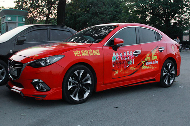 Mazda6 màu đỏ dán biểu ngữ và hình ảnh đội tuyển Việt Nam