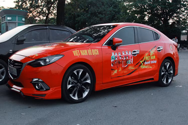 Mazda6 màu đỏ dán biểu ngữ và hình ảnh đội tuyển Việt Nam