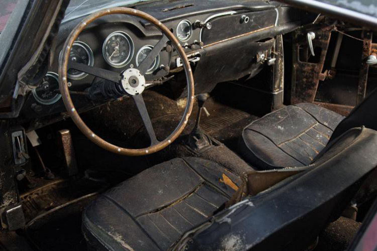 Bên trong chiêc Aston Martin đồng nát đã bị ẩm móc và xơ xác sau một thời gian dài dầm mưa, dãi nắng trong rừng.