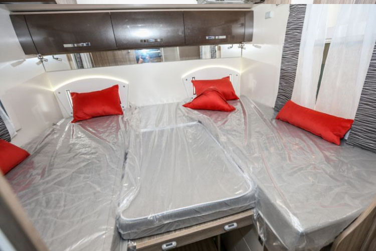 Phòng ngủ gồm ba chiếc giường nhỏ nhắn xếp cạnh nhau.