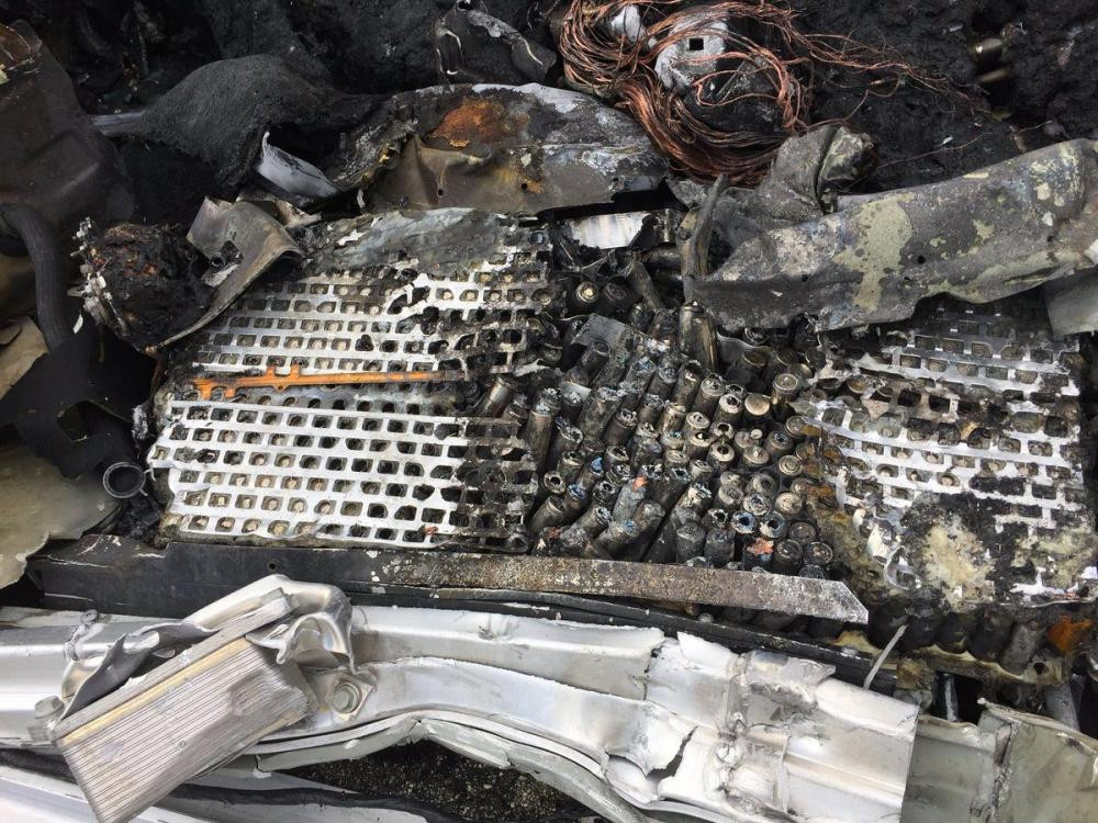 Va chạm mạnh đã khiến chiếc xe bốc cháy. Trong ảnh là cụm pin dưới sàn xe nhôi ra hoàn toàn.