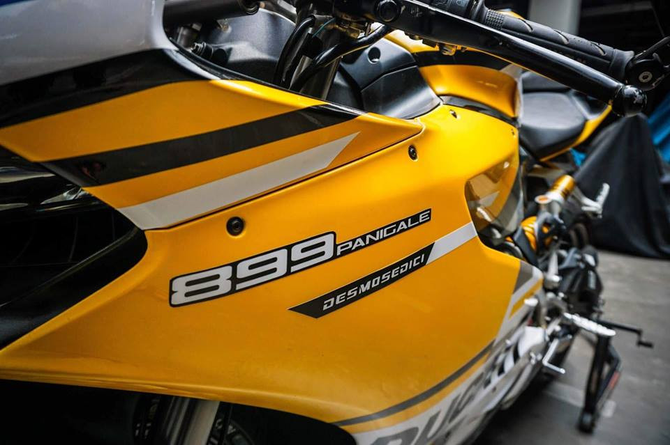 Logo Ducati Panigale 899 in trắng nổi bật trên nền vàng rực rỡ của xe.
