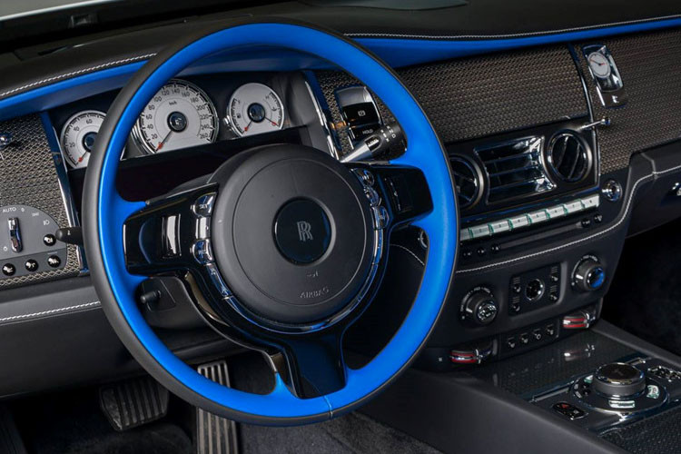 Cận cảnh vô lăng xe được sơn xanh tương phản với màu đen, xám chuột của nhiều trang bị xung quanh.