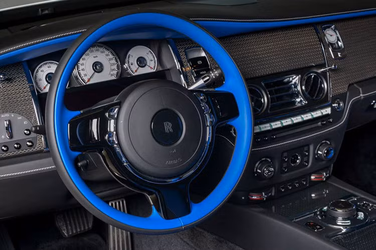 Cận cảnh vô lăng xe được sơn xanh tương phản với màu đen, xám chuột của nhiều trang bị xung quanh.