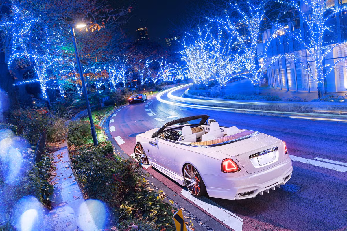 Bên cạnh nội thất màu trắng tinh khiến là những chi tiết được ốp gỗ hồng sắc sang trọng như bảng táp-lô, cụm điều khiển trung tâm, mặt cửa và khoang chứa mui đằng sau.