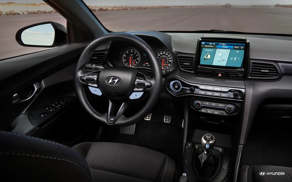 Nội thất mảu mẫu hatchback thể thao Veloster N 2019 đơn giản với màn hình trung tâm cảm ứng kích thước 8 inch tiêu chuẩn tích hợp hiển thị chế độ Performance cung cấp tình trạng xe và một đồng hồ tốc độ.