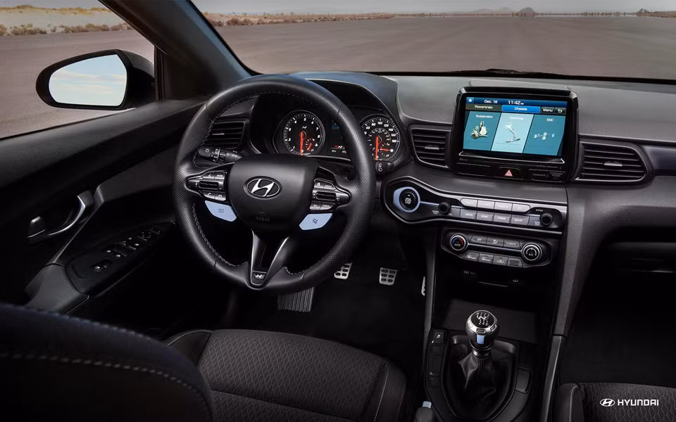 Nội thất mảu mẫu hatchback thể thao Veloster N 2019 đơn giản với màn hình trung tâm cảm ứng kích thước 8 inch tiêu chuẩn tích hợp hiển thị chế độ Performance cung cấp tình trạng xe và một đồng hồ tốc độ.