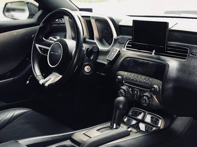 Nội thất bên trong xe cũng còn rất mới. Ghế ngồi trên xe được bọc da, ghế lái chỉnh điện 6 hướng. Vô-lăng 3 chấu bọc da tích hợp một số phím chức năng hỗ trợ người lái. Chiếc Camaro này còn được độ thêm màn hình cỡ lớn phục vụ giải trí cũng như hiển thị hệ thống camera 360 độ.