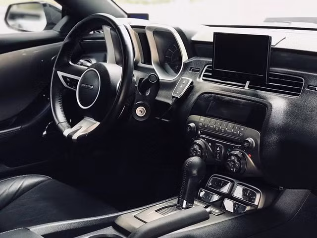 Nội thất bên trong xe cũng còn rất mới. Ghế ngồi trên xe được bọc da, ghế lái chỉnh điện 6 hướng. Vô-lăng 3 chấu bọc da tích hợp một số phím chức năng hỗ trợ người lái. Chiếc Camaro này còn được độ thêm màn hình cỡ lớn phục vụ giải trí cũng như hiển thị hệ thống camera 360 độ.