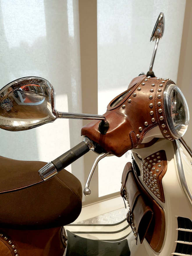 Những siêu phẩm Vespa bọc da này do hãng Bottega Conticelli sáng tạo nên. Tất cả các thao tác bọc da lên xe Vespa đều được tiến hành thủ công. Các tấm da được uống cầu kì, kết nối bằng loại chất sáp tạo độ chống nước rất tốt.