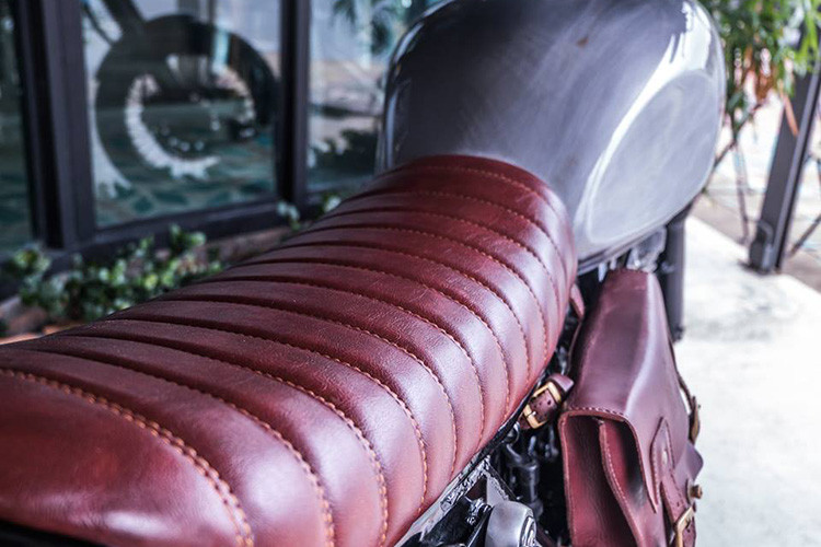 Yên xe được thiết kế dài hơn theo dạng bánh mỳ và được phủ lớp da bò thủ công tăng độ bám và độ êm cho người lái cùng bộ màu da bò đậm chất cổ điển, cùng tông với túi da treo hông đầy cá tính. 