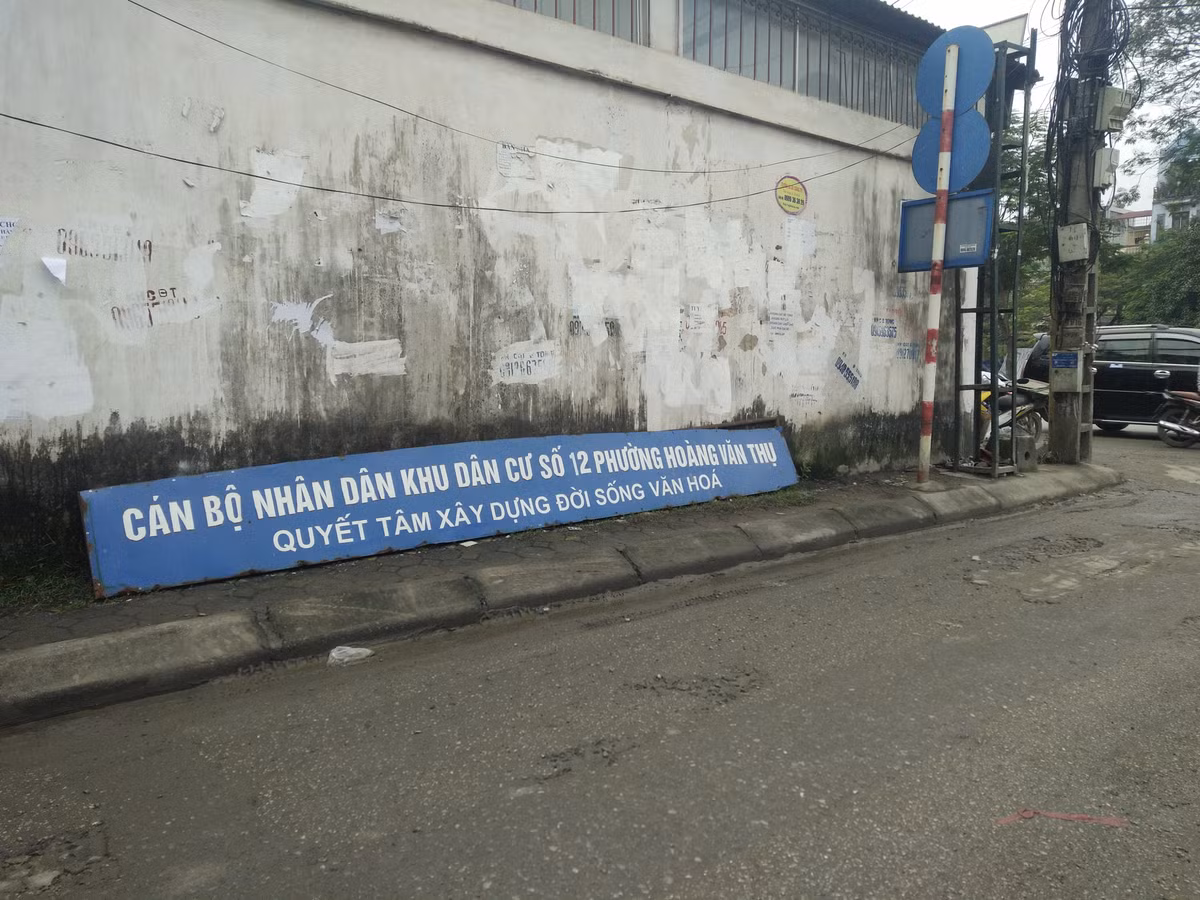 Hơn nữa phía cổng chào ra vào khu vực cụm dân cư xảy ra sự việc, tấm biển báo bị vứt nằm ngang một góc đường mà không được xử lý.