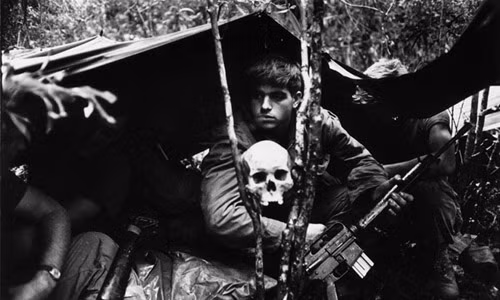 Một binh sĩ Mỹ làm nhiệm vụ tại một khu rừng trong Chiến tranh Việt Nam. Trước mặt binh sĩ này là chiếc đầu lâu đặt ở giữa 2 cành cây. Đây là một trong những hình ảnh ám ảnh về Chiến tranh Việt Nam.