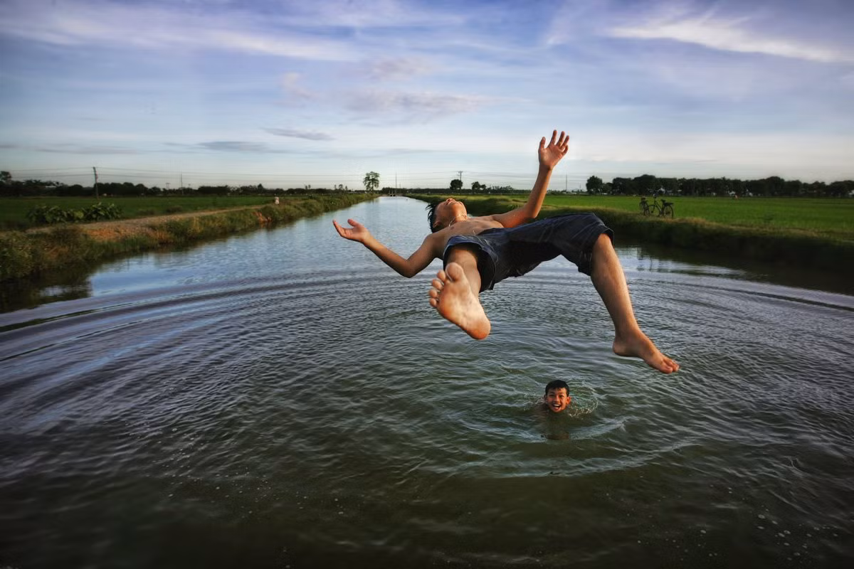 Theo đó, các nhiếp ảnh gia sẽ tranh tài ở 6 hạng mục trong cuộc thi ảnh quốc tế thường niên lần thứ 12 của Tạp chí Smithsonian bao gồm: Thế giới thiên nhiên, Du lịch, Con người, Nước Mỹ, Ảnh có chỉnh sửa và Ảnh chụp bằng điện thoại. Trong ảnh là bé trai nhảy xuống sông tắm mát, chơi đùa tại ngôi làng ở xã Nghiêm Xuyên của nhiếp ảnh gia Viet Phuong Tran. Bức ảnh này tranh tài ở hạng mục Con người.