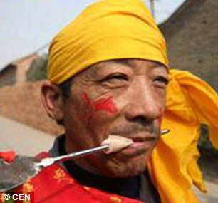 Trong ảnh là một người đàn ông ở tỉnh Sơn Tây thực hiện nghi lễ cổ xưa xuyên thanh sắt nhọn qua miệng.