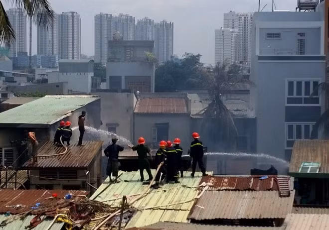 Cảnh sát PCCC phải leo lên nóc các căn nhà bên cạnh để phun nước, cô lập đám cháy.