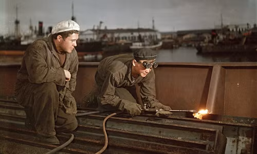 Hai công nhân hàn xì làm việc gần bến cảng.