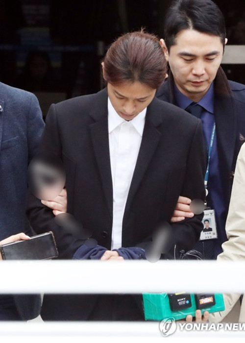 Đến trưa ngày 21/3, cựu ca sĩ rời tòa án với hình ảnh bị cảnh sát trói chặt 2, còng tay. Ảnh: Yonhapnews