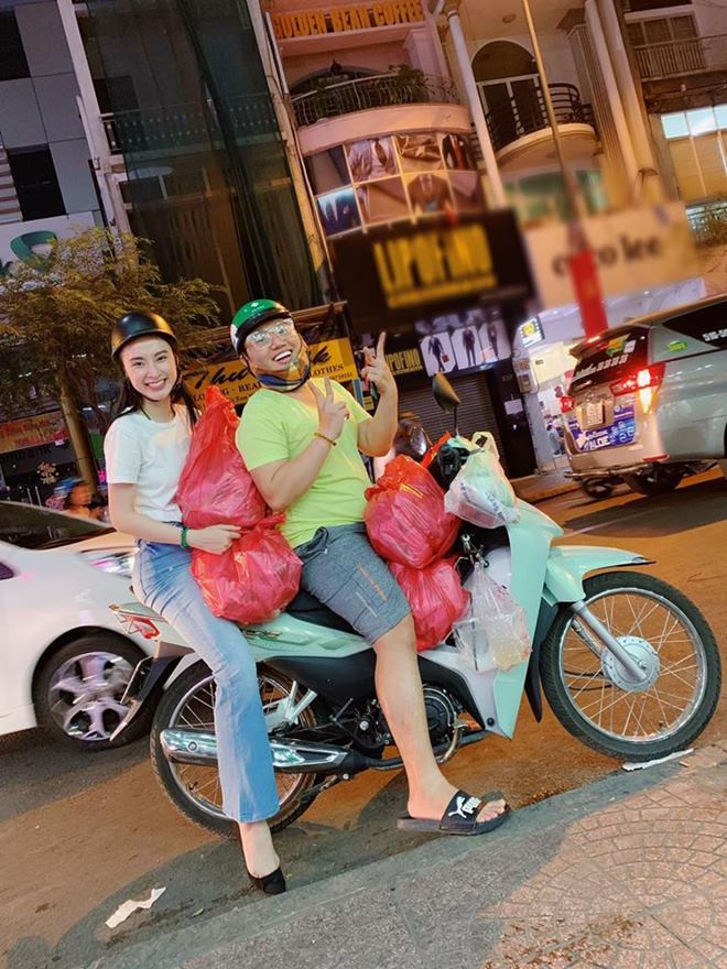 Nữ diễn viên 9X cùng một người bạn đi xe máy phát đồ ăn chay cho bà con.