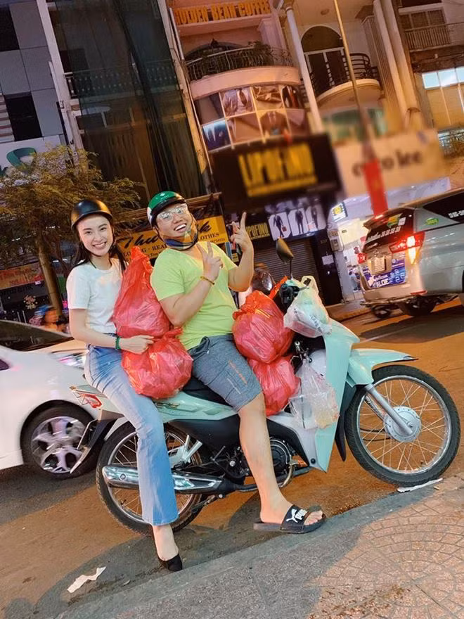 Nữ diễn viên 9X cùng một người bạn đi xe máy phát đồ ăn chay cho bà con.