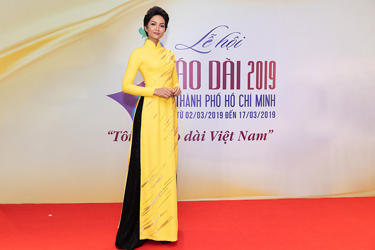 H'hen Niê diện tà áo dài vàng đơn giản kết hợp cùng quần đen đậm chất Sài Gòn xưa.