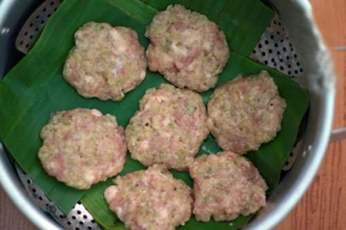  Bước 4: Sau khi chả cốm đã nặn xong sẽ tiến hành hấp chín. Bạn Lót một lớp lá chuối xuống đáy nồi hấp, rồi xếp những miếng chả đã nặn lên. Hấp chả ở nhiệt độ cao trong 15 phút. Việc hấp chả sẽ giữ được độ ngọt tự nhiên của cốm, khi chiên chả nhanh chín mà lại không bị ra nước. Đây là bí quyết quan trọng để miếng chả ngon đúng điệu. 