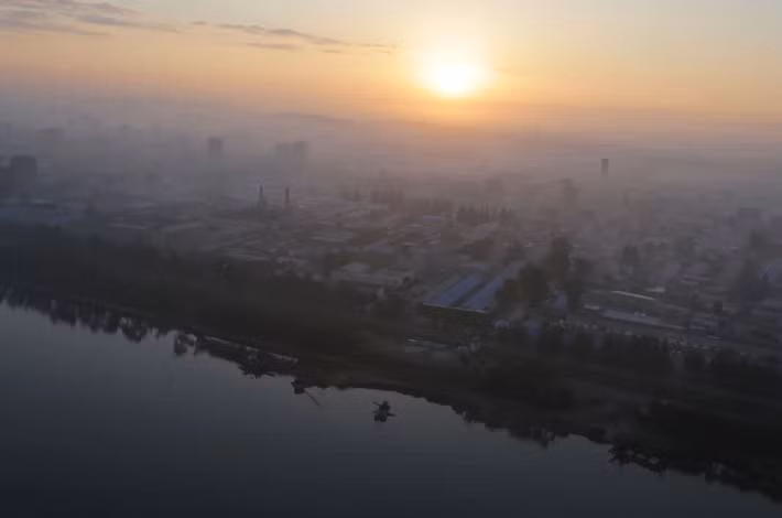 Những tòa chung cư dần hiện ra trong màn sương buổi sáng khi mặt trời mọc ở thủ đô của Triều Tiên ngày 28/8/2014.