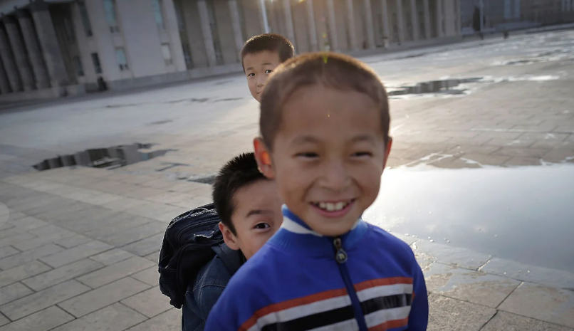 Các em nhỏ chơi trượt patin tại Quảng trường Kim Nhật Thành cười tươi trước ống kính.