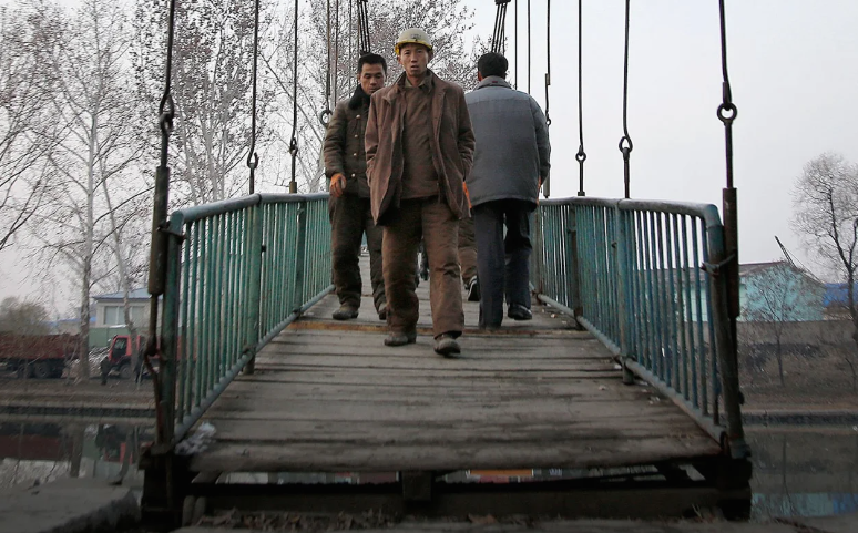 Những người công nhân xây dựng đi qua cây cầu bắc qua sông Pothong ở Bình Nhưỡng ngày 28/11/2015. Theo AP, Pothong là con sông lớn thứ hai chảy qua thủ đô Triều Tiên.